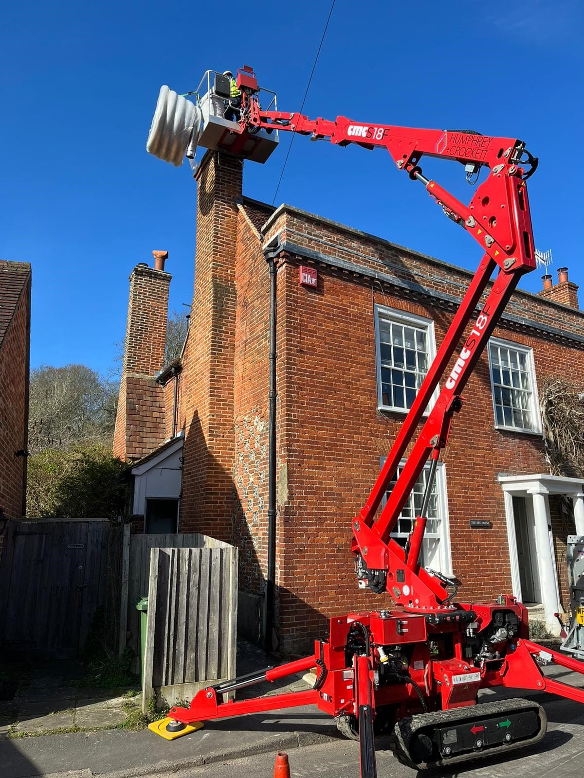 Humphrey & Crockett with their cherry picker, repairing a chimney.