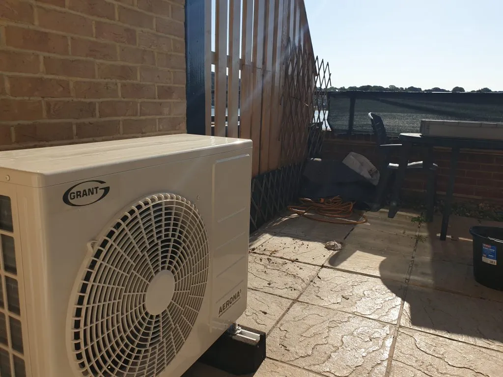Grant air source heat pump in the courtyard to a home in Hampshire.